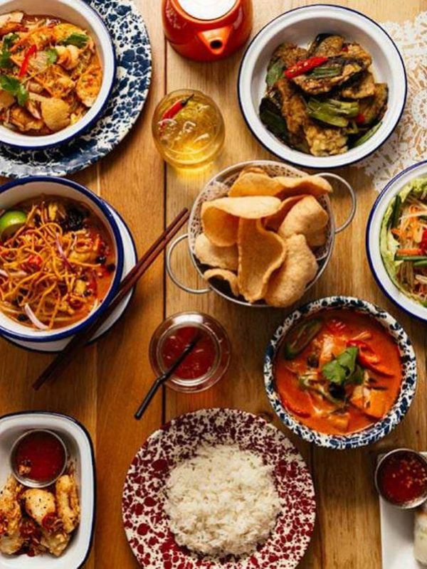 Birds' eye view of a table of Thai dishes at a Rosa's Thai restaurant.